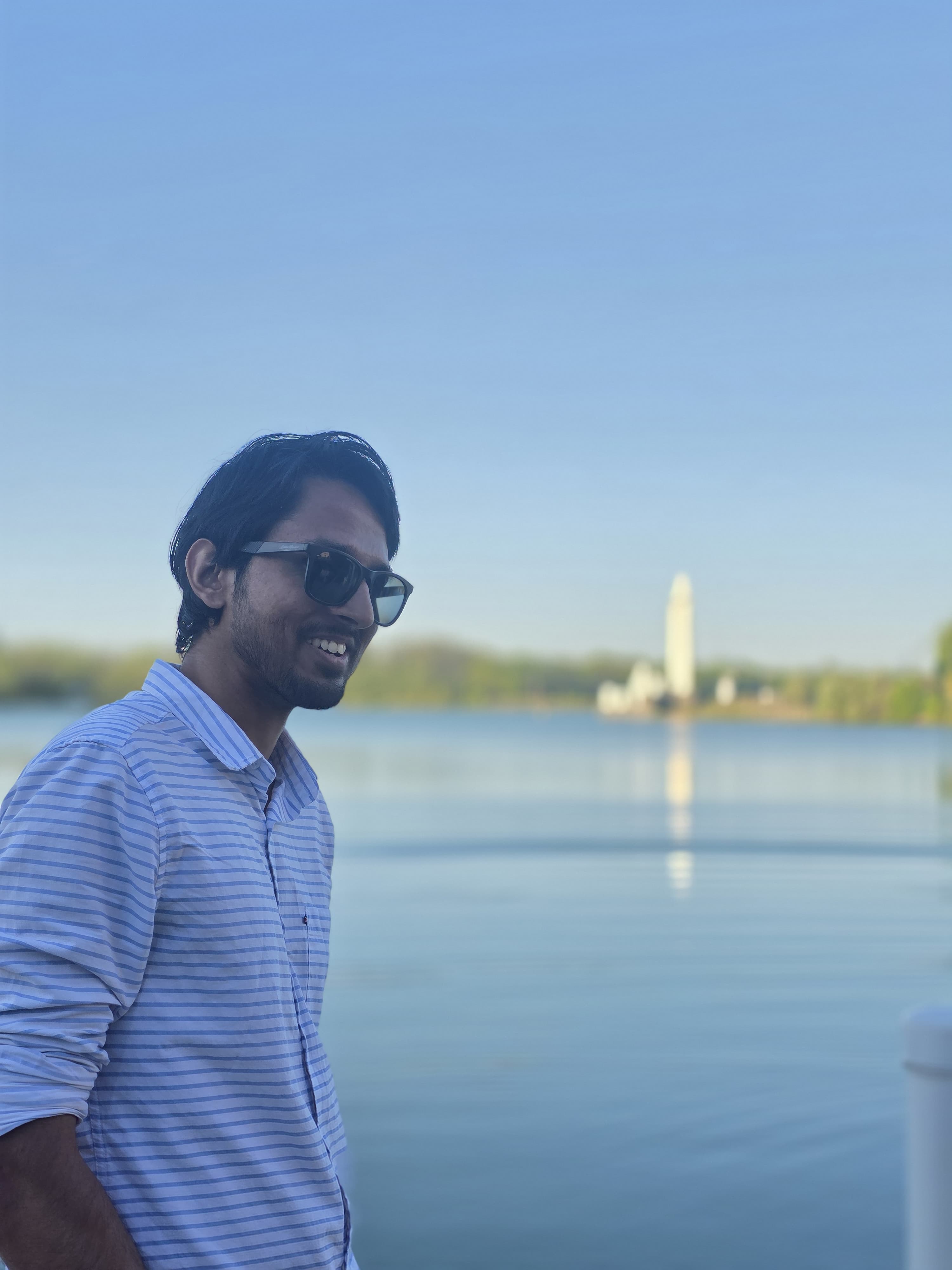 Adnan beside Lake LaSalle on the University at Buffalo North Campus, the lake fountain visible across the water